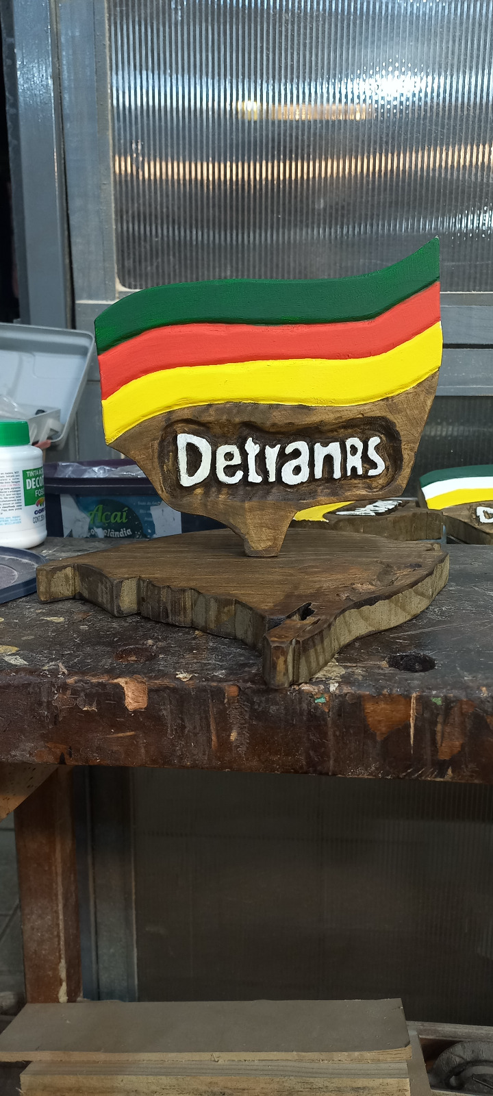 Troféu artesanal em madeira maciça feito sob encomenda para o DETRAN RS, com bandeira do Rio Grande do Sul entalhada e pintada à mão e letras em alto relevo