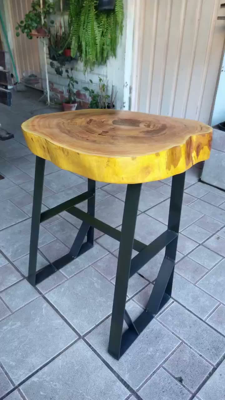 Mesa banqueta alta com estrutura em ferro de construção pintado de preto e tampo em bolacha de madeira nativa envernizada