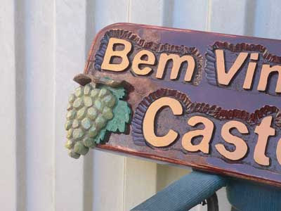 Detalhe aproximado do cacho de uvas esculpido em super alto relevo aplicado sobre a placa da Vinícola Castello Mattei