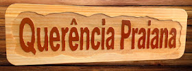Placa em madeira pinus com o nome "Querência Praiana" entalhado em letras de alto relevo e acabamento envernizado